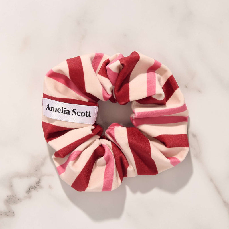 Amelia Scott pink and red striped hair scrunchie on marble background