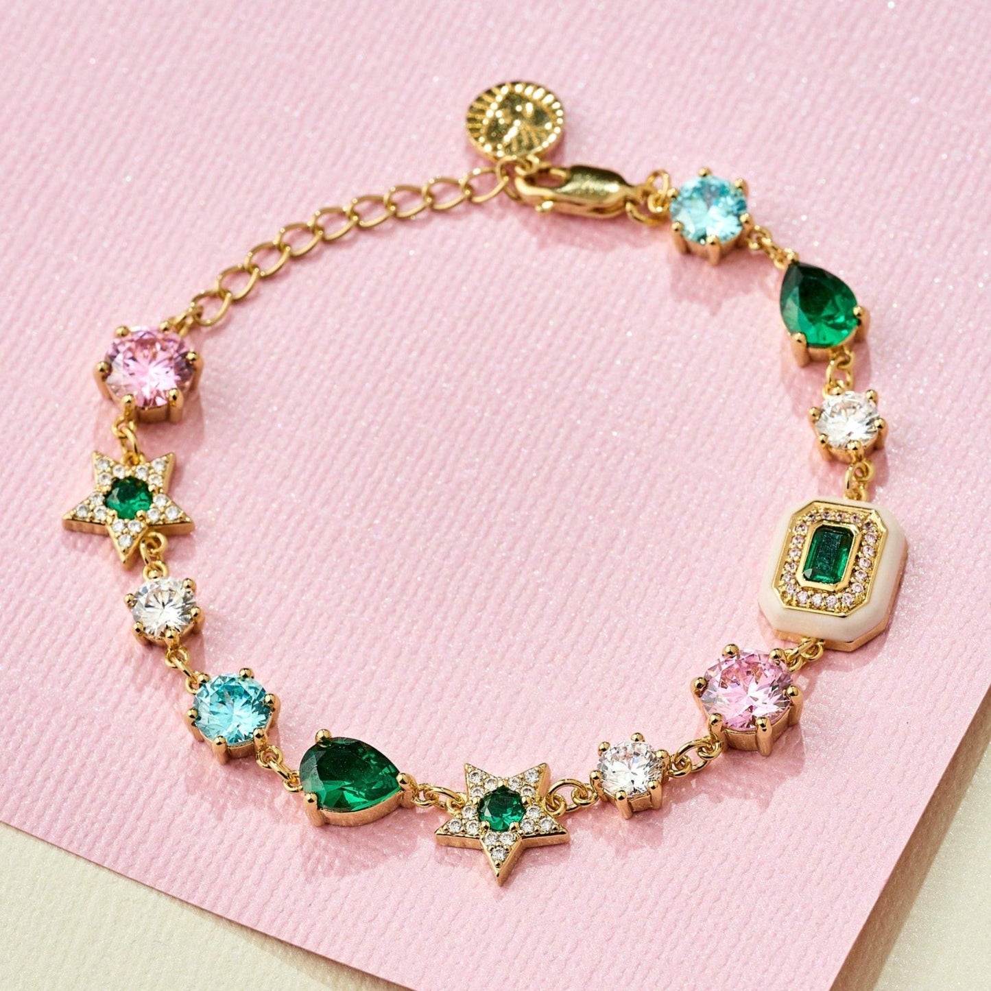 Celeste Cluster Bracelet with blush pink enamel, emerald green and gold on pink background