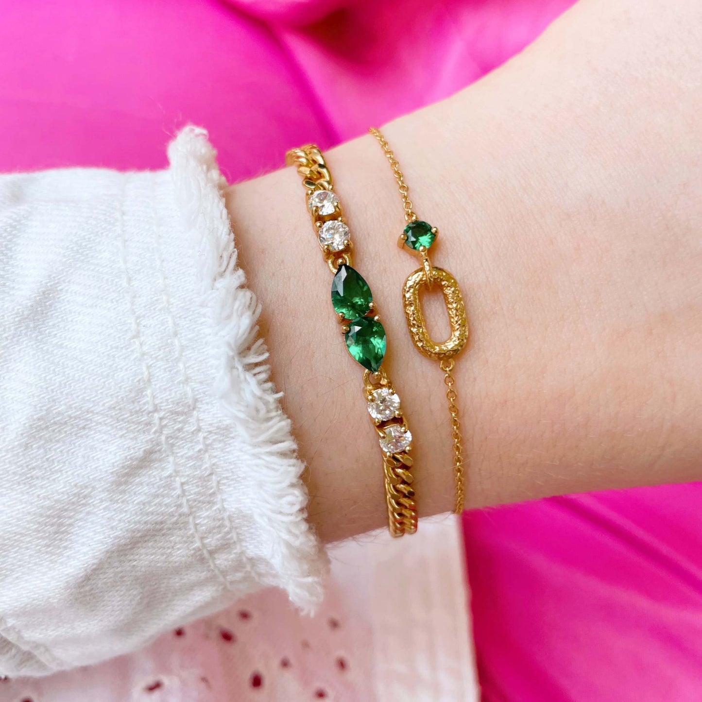 Emerald Green and Gold Stacking Bracelet Set on the wrist over a pink background