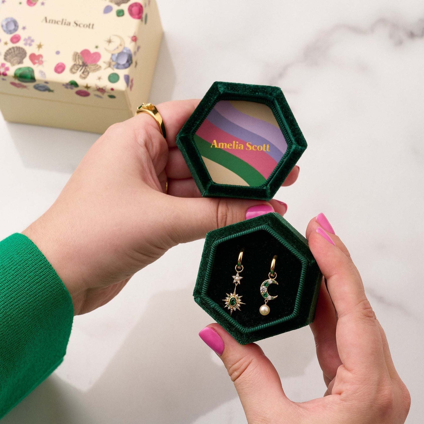 Moon & Star Huggie Hoop Earrings in gold and emerald green, packaged in emerald green luxury velvet gift box