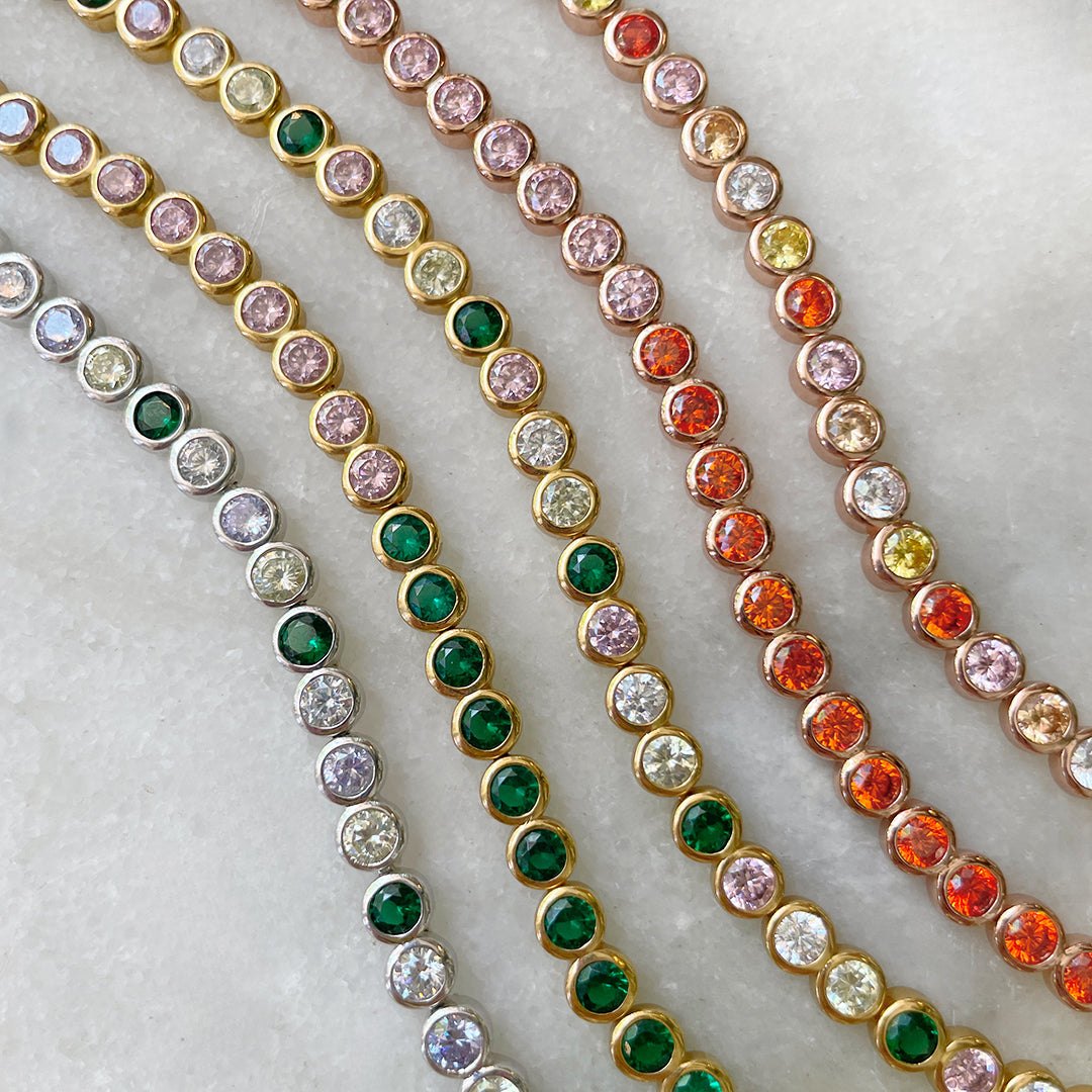 Rose Gold Tennis Bracelet Pink & Orange laid flat with other colourful tennis bracelets