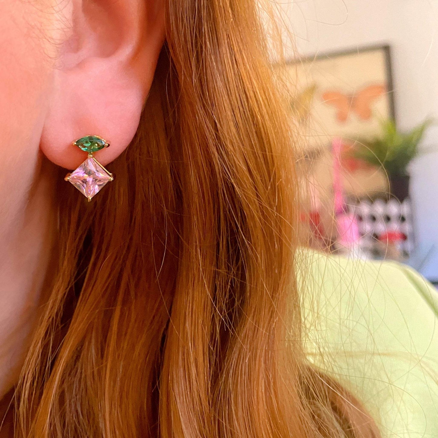 Unusual gold earrings, emerald green and pink cubic zirconia studs styled in ear