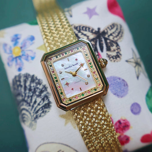 Celeste Stargazer Watch with gold mesh band and mother-of-pearl dial adorned with multicolored stones and star motifs